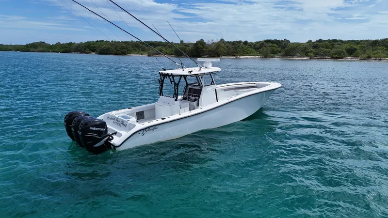 Slide: The Image of 2017 Yellowfin 36 Offshore boat on clear blue water near a lush shoreline. - 3