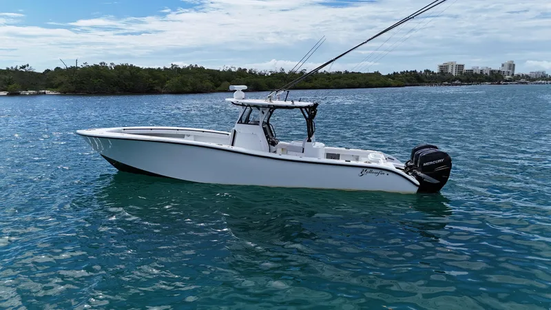 Slide: The Image of 2017 Yellowfin 36 Offshore boat on calm blue water, with fishing rods and Mercury engines. - 9
