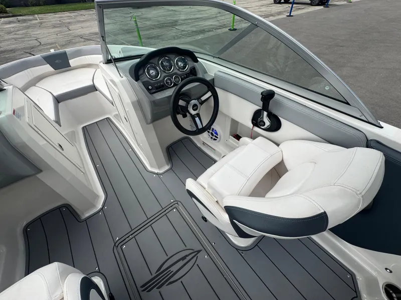 Slide: The Image of 2021 Chaparral 19 SSI Sport boat interior with steering wheel and seating. - 14
