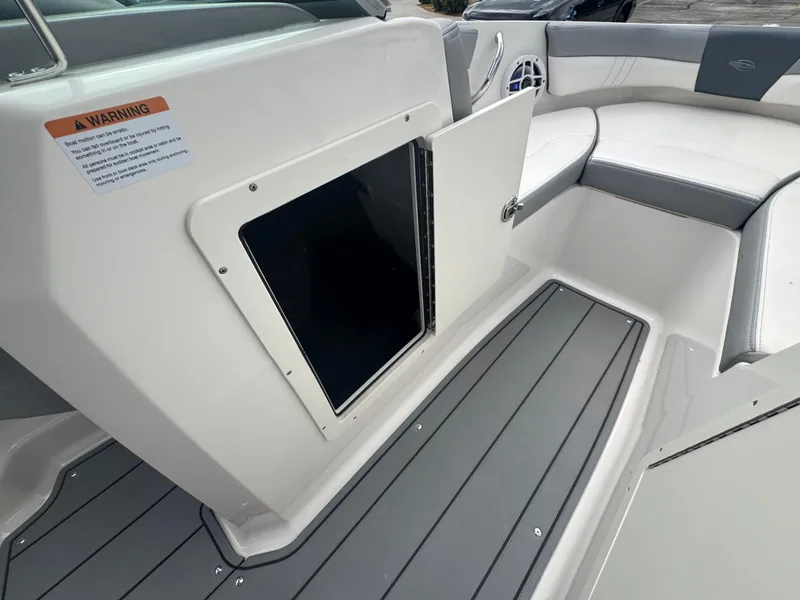 Slide: The Image of 2021 Chaparral 19 SSI Sport boat interior with open storage compartment and seating. - 16