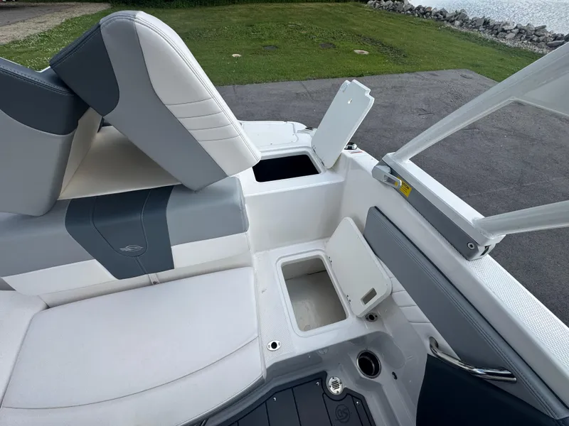 Slide: The Image of 2021 Chaparral 19 SSI Sport boat interior with open storage compartments and seating. - 20