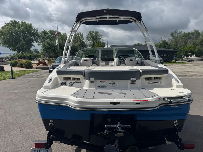 Slide: The Image of 2021 Chaparral 19 SSI Sport boat, rear view, parked outdoors under cloudy sky. - 4