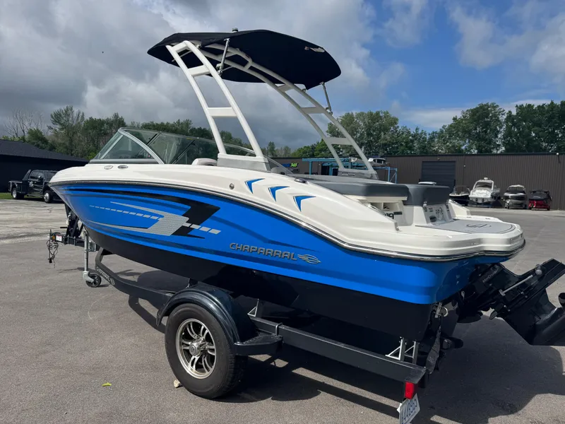 Slide: The Image of 2021 Chaparral 19 SSI Sport boat with blue and white design on a trailer. - 5