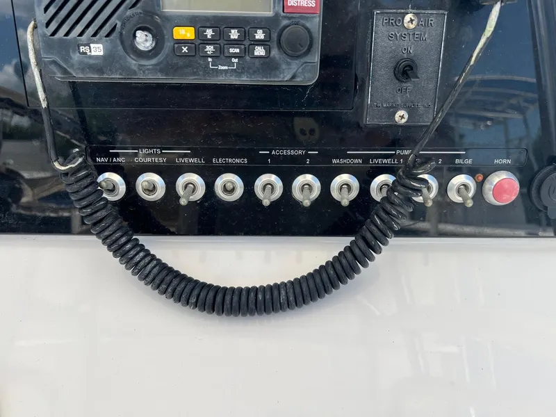 Slide: The Image of Control panel of a 2015 Sportsman Masters 247 Bay Boat with switches and radio. - 23