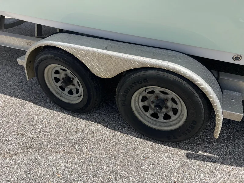 Slide: The Image of Trailer wheels of a 2015 Sportsman Masters 247 Bay Boat on asphalt. - 4