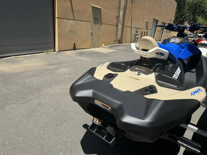 Slide: The Image of 2025 Sea-Doo SPARK TRIXX 3up jet ski parked outdoors on pavement. - 5