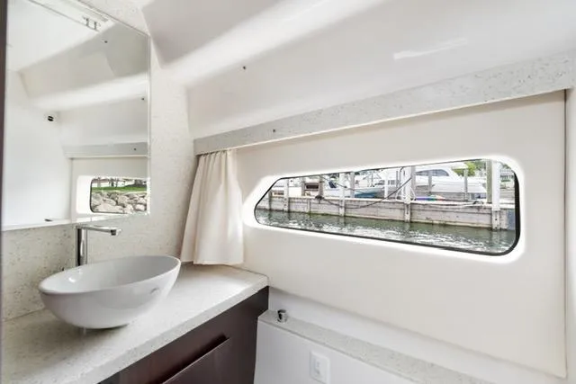 Slide: The Image of Luxurious bathroom interior of 2017 Regal 42 Grande Coupe yacht with modern sink and window view. - 17