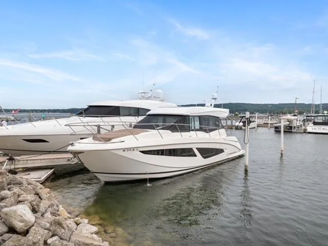 Slide: The Image of 2017 Regal 42 Grande Coupe yacht docked at marina under clear blue sky. - 2
