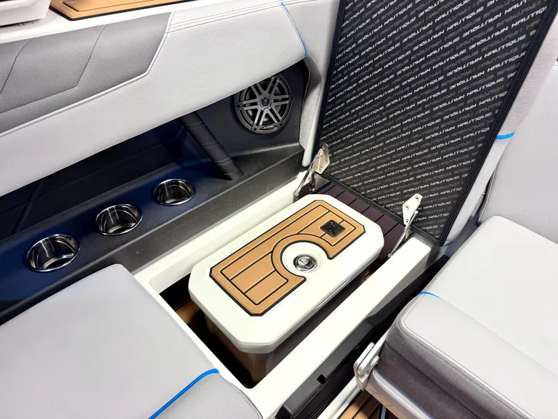 Slide: The Image of 2025 Nautique Super Air Nautique S23 interior with cup holders and storage compartment. - 30
