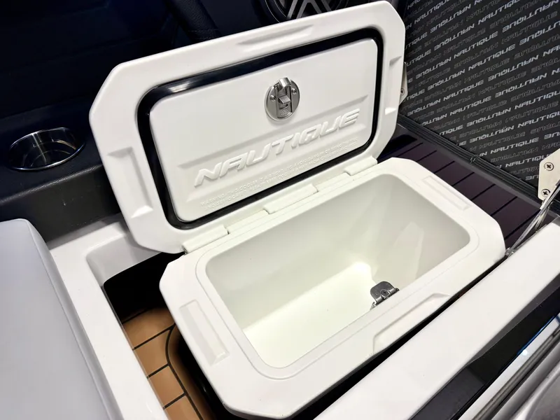 Slide: The Image of 2025 Nautique Super Air Nautique S23 cooler compartment, open lid, sleek design. - 31
