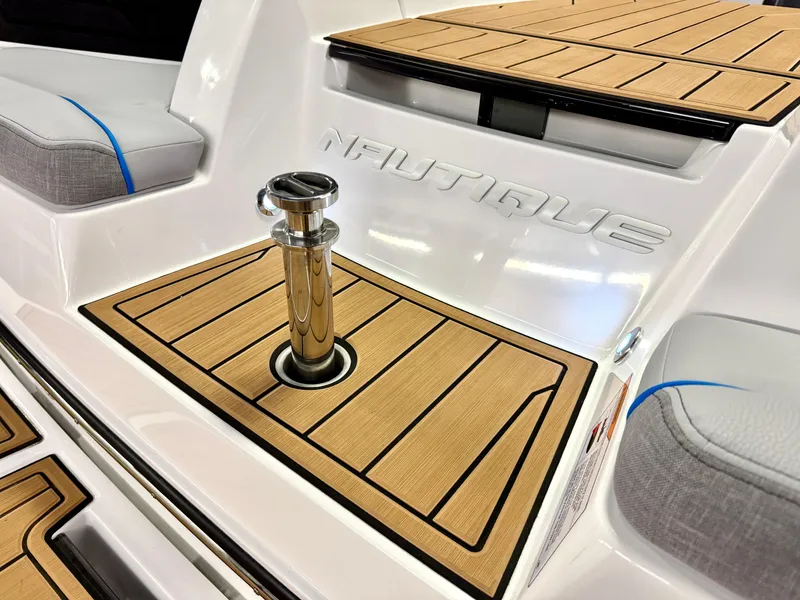 Slide: The Image of 2025 Nautique Super Air Nautique S23 boat deck with teak flooring and chrome details. - 40