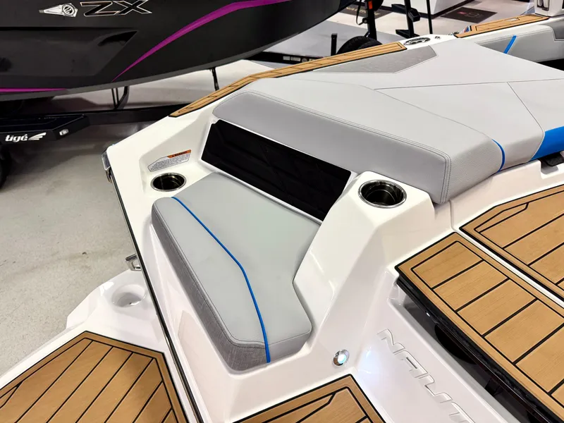 Slide: The Image of 2025 Nautique Super Air Nautique S23 boat interior with cushioned seating and cup holders. - 41