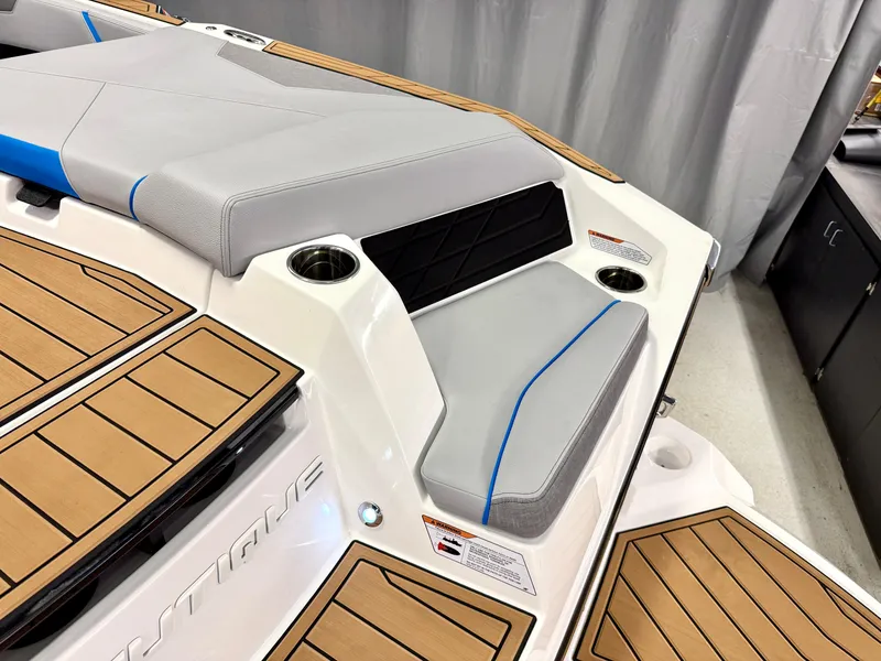 Slide: The Image of 2025 Nautique Super Air Nautique S23 boat interior with cushioned seating and teak flooring. - 42