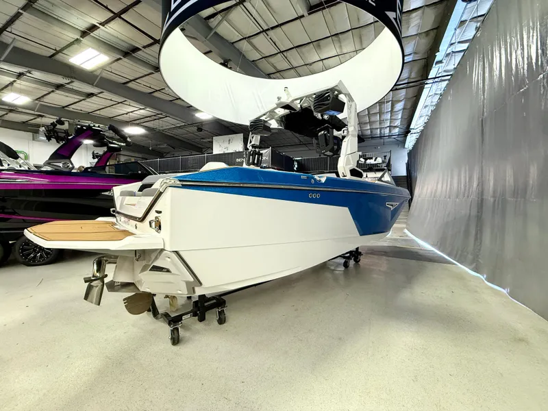 Slide: The Image of 2025 Nautique Super Air Nautique S23 boat in showroom, blue and white design. - 5