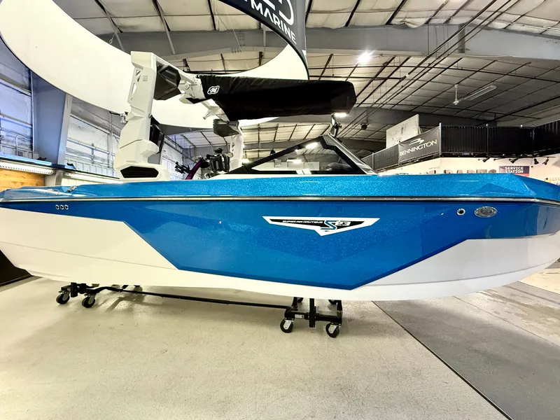 Slide: The Image of 2025 Nautique Super Air Nautique S23 boat in showroom, blue and white design. - 6