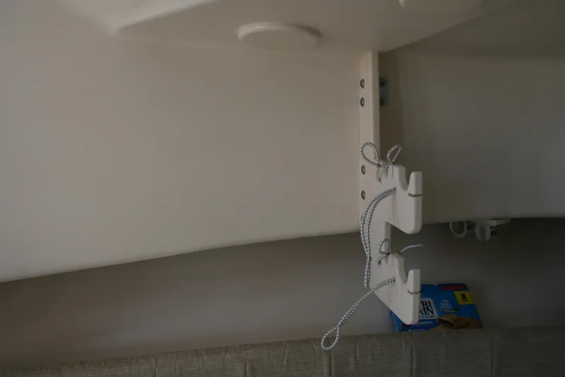 Slide: The Image of Interior view of 2021 Grady-White 232 Gulfstream boat with storage hooks and a snack box. - 12