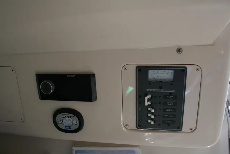 Slide: The Image of Control panel of 2021 Grady-White 232 Gulfstream boat, featuring switches and a voltage meter. - 13