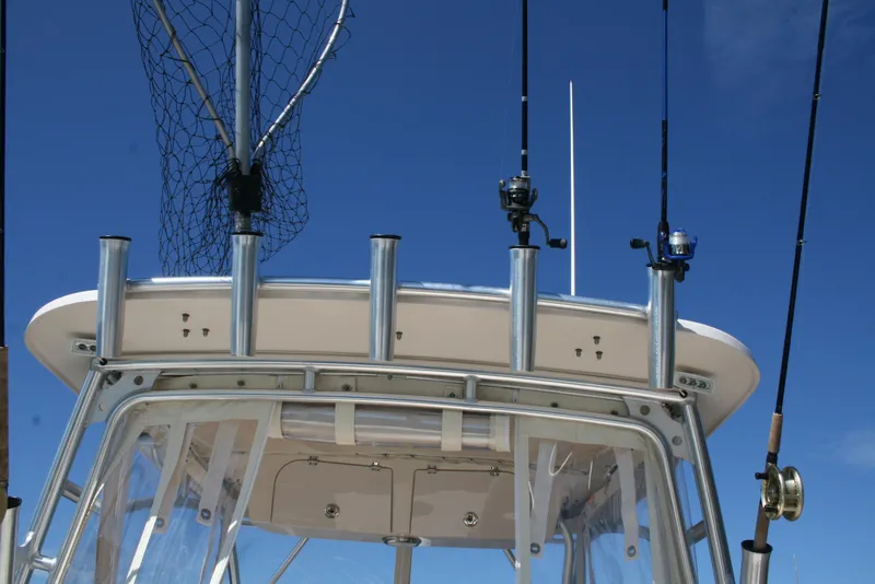 Slide: The Image of Fishing rods and net on a 2021 Grady-White 232 Gulfstream boat against a clear blue sky. - 19