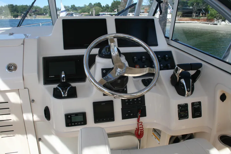 Slide: The Image of 2021 Grady-White 232 Gulfstream boat dashboard with steering wheel and navigation controls. - 3