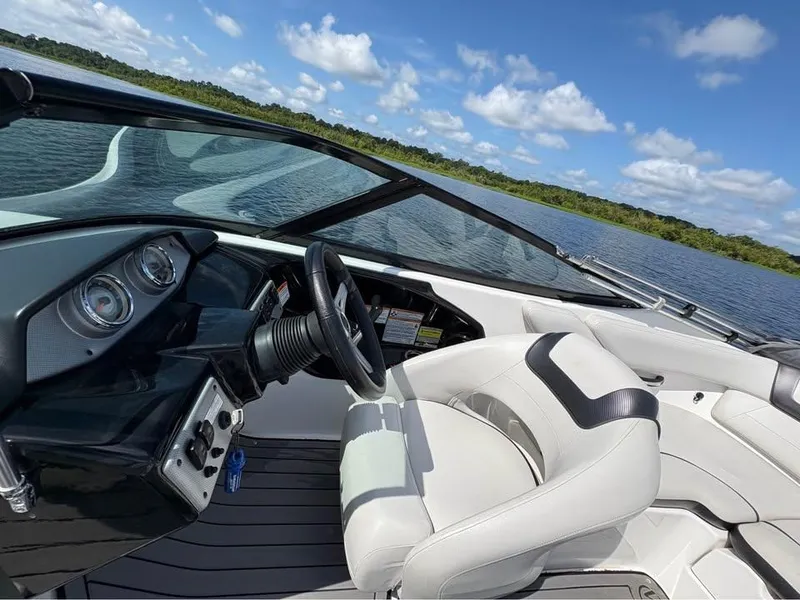 Slide: The Image of 2014 Yamaha SX192 boat interior with steering wheel, dashboard, and seating on a sunny day. - 9