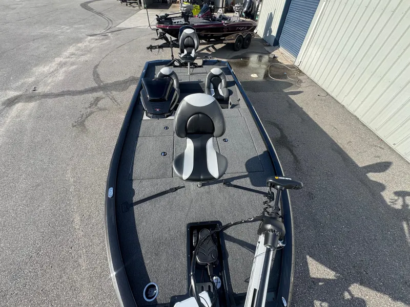 Slide: The Image of 2026 Vexus AVX1980 fishing boat with seating and trolling motor, parked outdoors. - 5