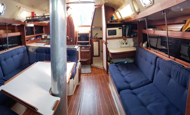 Slide: The Image of Interior of a 1988 Catalina 38 MKi sailboat with blue seating and wooden accents. - 4