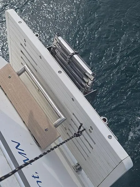 Slide: The Image of Sailboat swim platform and ladder on 1988 Catalina 38 MKi over water. - 8