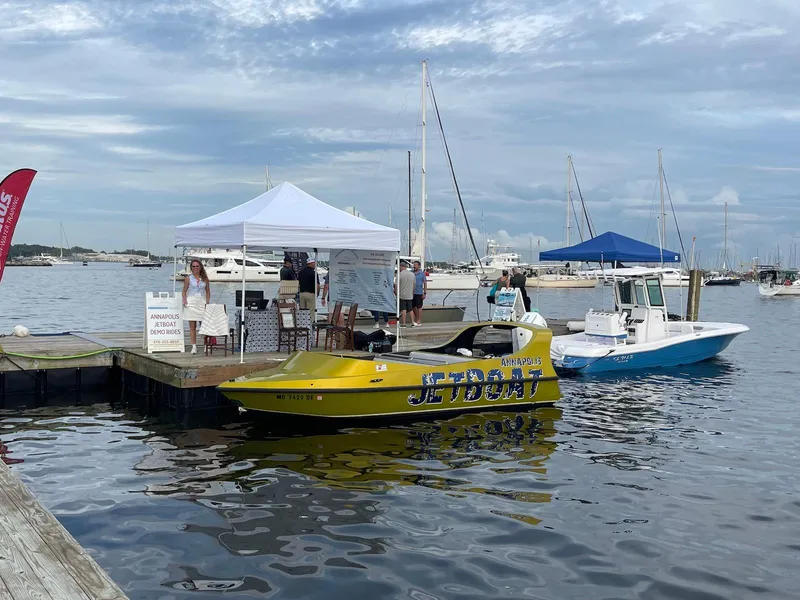 Slide: The Image of Yellow Smokey Mountain Jet Boat docked at marina, offering demo rides under a white tent. - 2
