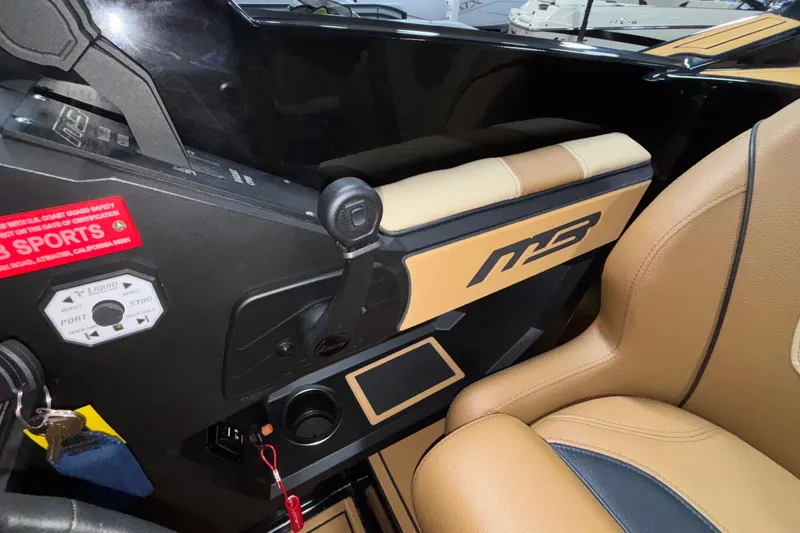 Slide: The Image of Interior of 2025 MB B52 25 Alpha boat with tan leather seating and control panel. - 24