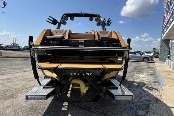 Slide: The Image of 2025 MB B52 25 Alpha boat, rear view, parked outdoors under a clear sky. - 1