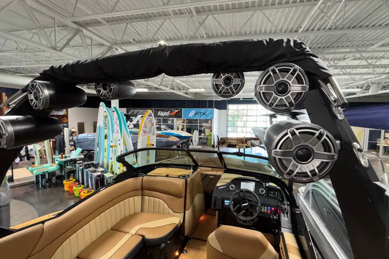 Slide: The Image of 2025 MB B52 25 Alpha boat interior with speakers and surfboards in showroom. - 46