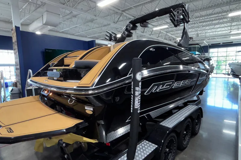 Slide: The Image of 2025 MB B52 25 Alpha boat in showroom, sleek black design with tan interior. - 49