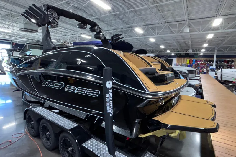 Slide: The Image of 2025 MB B52 25 Alpha boat on trailer in showroom, featuring sleek black design. - 50