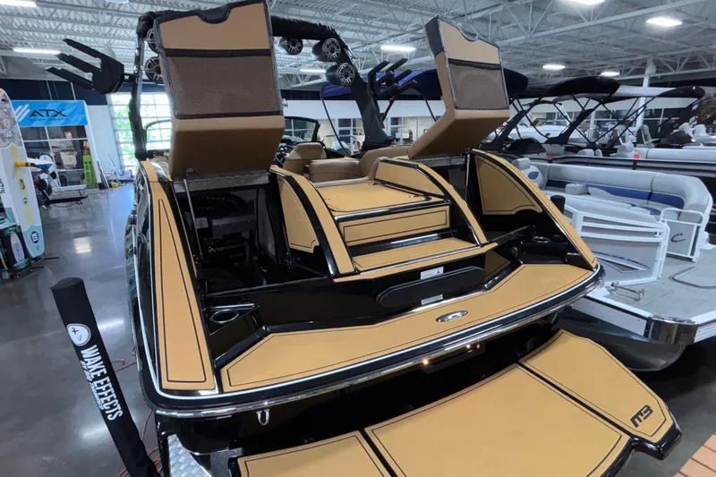 Slide: The Image of 2025 MB B52 25 Alpha boat with tan upholstery and sleek design in showroom. - 51