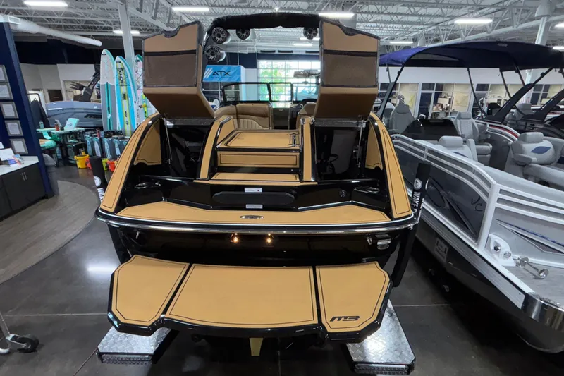 Slide: The Image of 2025 MB B52 25 Alpha boat in showroom, featuring sleek design and tan accents. - 52
