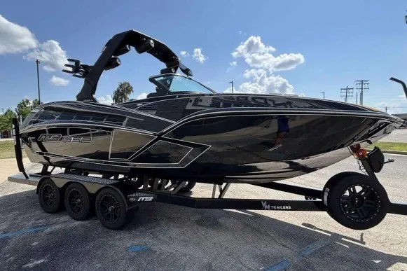 Slide: The Image of 2025 MB B52 25 Alpha boat on trailer, sleek black design under clear blue sky. - 3