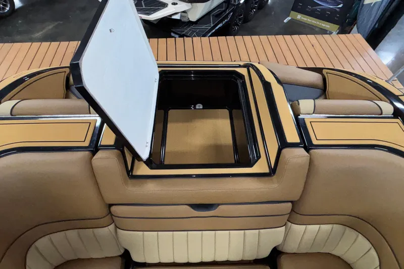 Slide: The Image of 2025 MB B52 25 Alpha boat interior with open storage compartment, tan and beige upholstery. - 54
