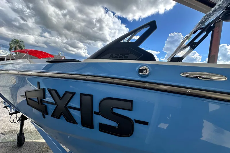 Slide: The Image of 2026 Axis A225 boat with sleek blue design under cloudy sky. - 14