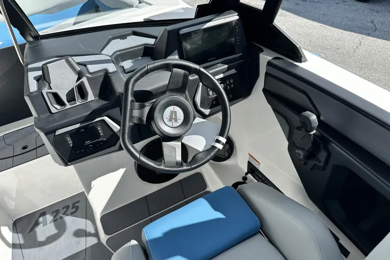 Slide: The Image of 2026 Axis A225 boat cockpit with steering wheel and control panel. - 2