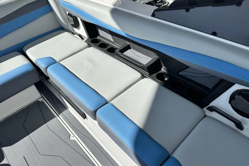Slide: The Image of 2026 Axis A225 boat interior with blue and gray seating and cup holders. - 5
