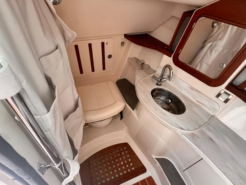 Slide: The Image of 2016 Grady-White Freedom 375 boat bathroom with sink, mirror, and shower curtain. - 18