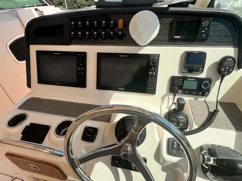 Slide: The Image of Control panel of a 2016 Grady-White Freedom 375 boat with navigation screens and steering wheel. - 23
