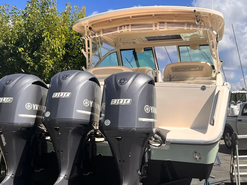 Slide: The Image of 2016 Grady-White Freedom 375 boat with triple Yamaha 300 engines, docked under a clear sky. - 4