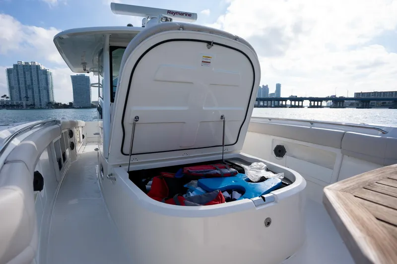 Slide: The Image of 2020 Boston Whaler 380 Outrage boat with open storage compartment, city skyline in background. - 17