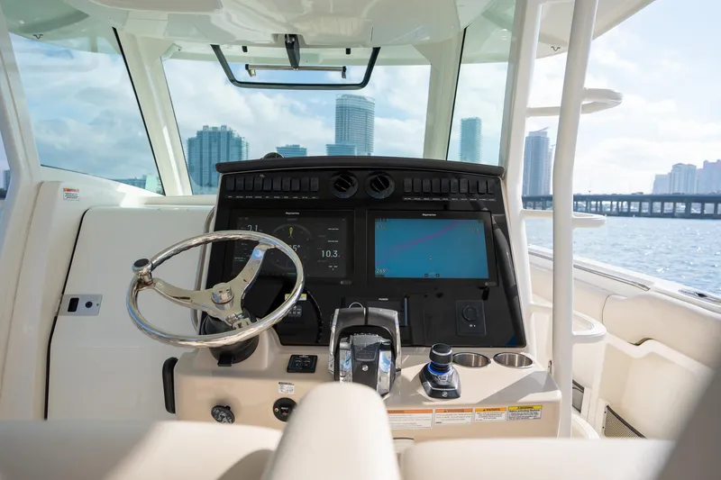 Slide: The Image of 2020 Boston Whaler 380 Outrage helm with modern navigation system, city skyline in background. - 25