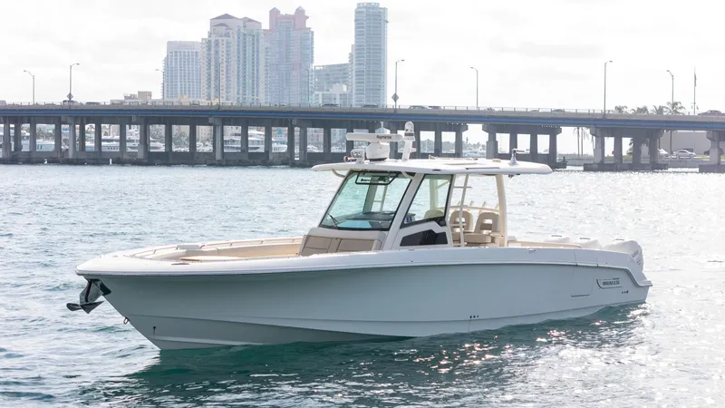 Slide: The Image of 2020 Boston Whaler 380 Outrage boat on water with cityscape and bridge in background. - 3