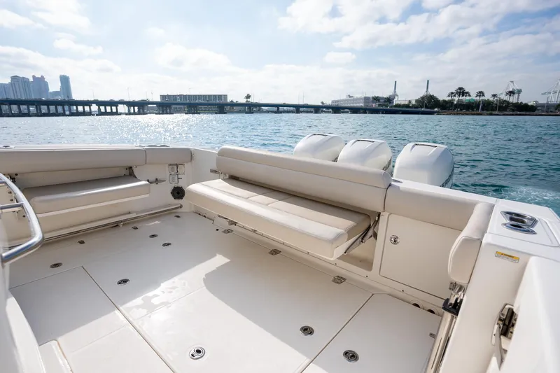 Slide: The Image of 2020 Boston Whaler 380 Outrage boat interior with seating, ocean view, and city skyline. - 30