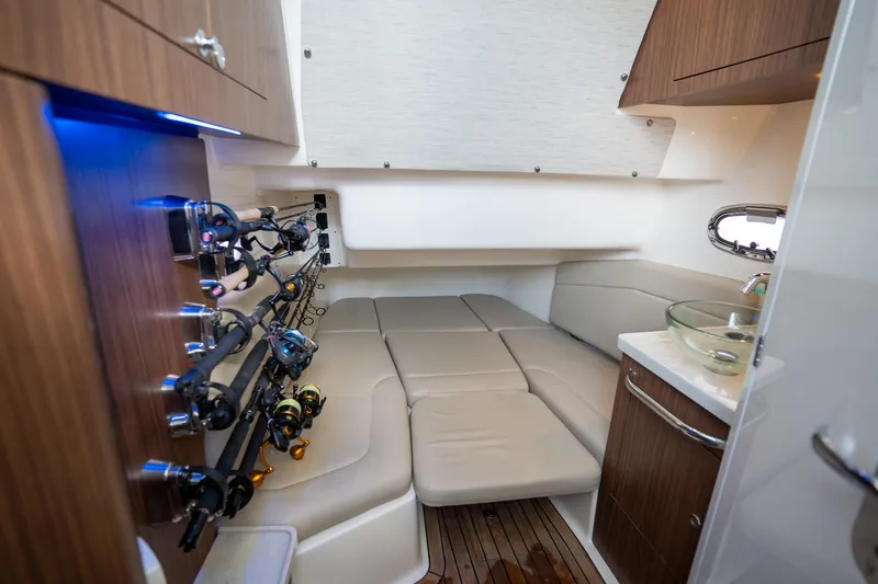 Slide: The Image of Interior of 2020 Boston Whaler 380 Outrage with fishing rods and cozy seating area. - 32