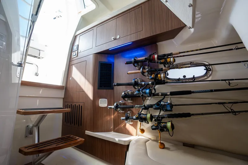 Slide: The Image of Interior of 2020 Boston Whaler 380 Outrage with fishing rods and wooden cabinetry. - 35