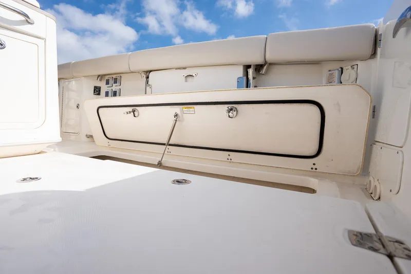 Slide: The Image of Boston Whaler 380 Outrage 2020 boat interior with storage compartment, white seating, and blue sky. - 37